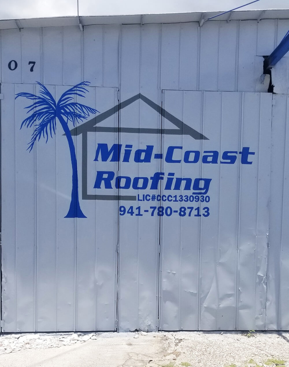 Mid Coast Roofing Logo Painted on a White Metal Wall