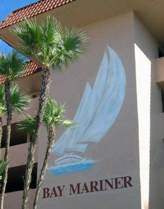Painting of Bay Mariner Logo With Boat Outside Building